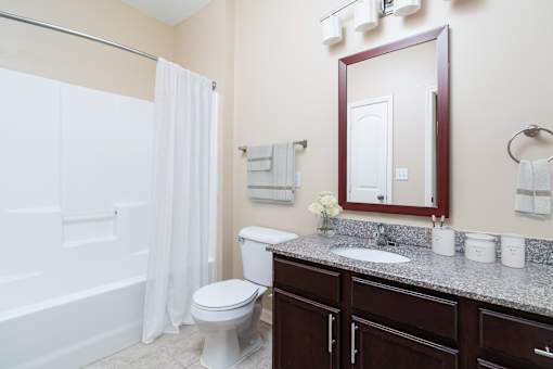 A bathroom with a toilet, sink, and shower.