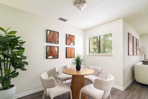 A room with a table and chairs and pictures on the wall.