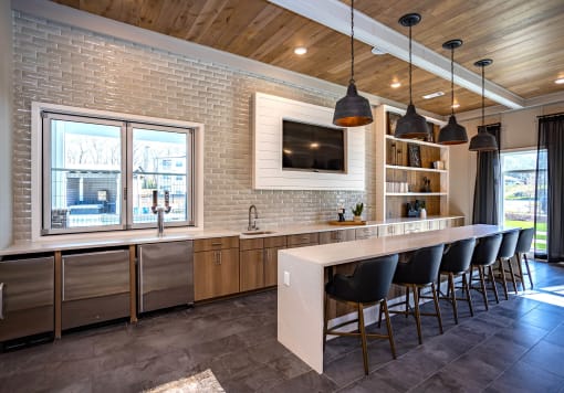 a kitchen with brick walls and a long island with a long white countertop