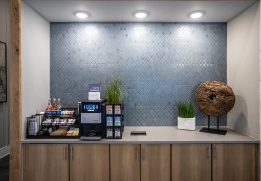 a lobby with a coffee machine and a wall with a blue patterned wall paper
