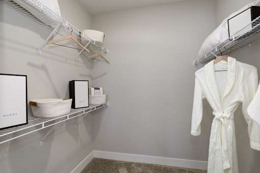 A white robe is hanging on a rack in a room.