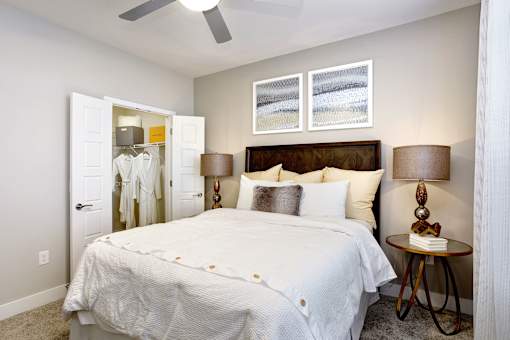A bedroom with a large bed and a ceiling fan.