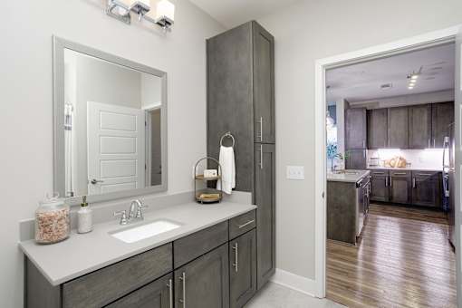 A bathroom with a sink, mirror, and wooden cabinets.