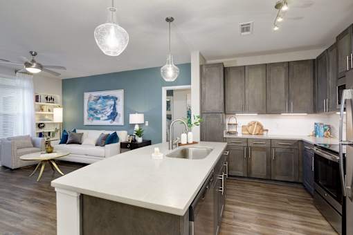 A modern kitchen with a white countertop and stainless steel appliances.