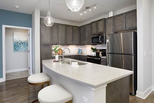 A kitchen with a white counter top and a refrigerator.