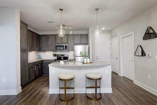 A kitchen with a bar stool in front of the island.