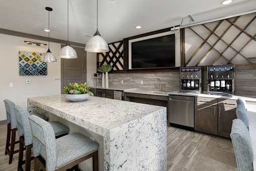 A kitchen with a marble countertop and a large island.