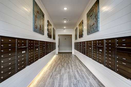 A hallway with a series of mailboxes on the wall.