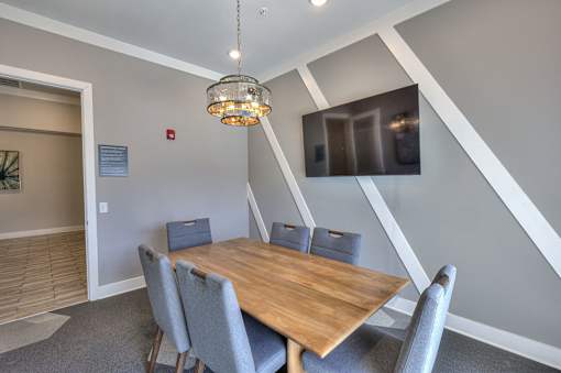 A dining room with a wooden table and grey chairs.