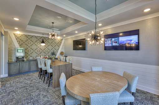 A modern dining room with a wooden table and grey chairs.