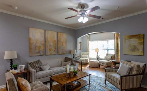 a living room with couches and a ceiling fan
