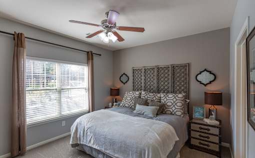 a bedroom with a bed and a ceiling fan