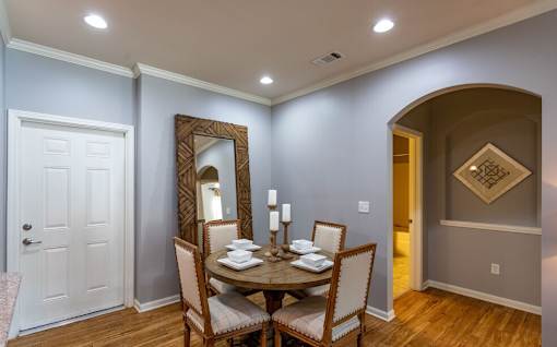 a dining room with a table and chairs and a mirror