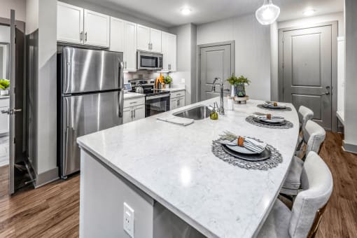 a kitchen with stainless steel appliances and a marble counter top