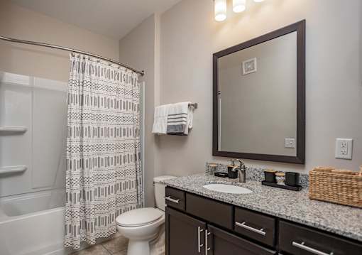 a bathroom with a shower toilet and sink and a mirror