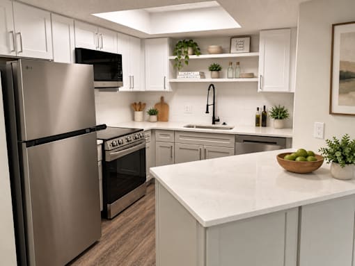 A modern kitchen with a stainless steel refrigerator and a marble countertop.