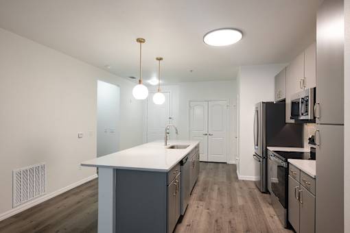 A kitchen with a white counter top and black appliances.