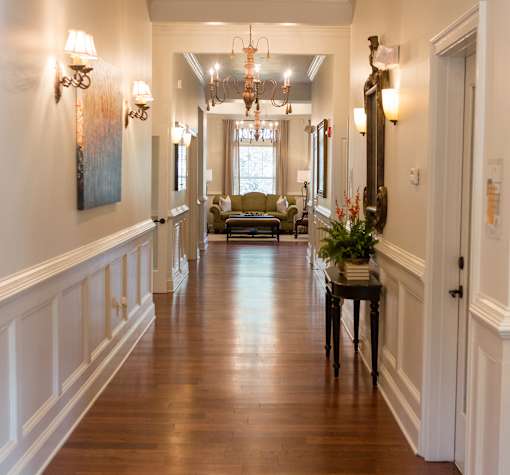 A long hallway with a table and chairs in the middle.