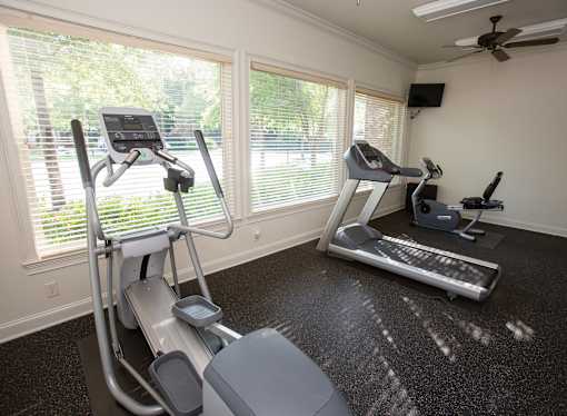 A home gym with treadmills and elliptical machines.