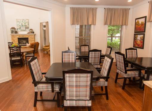A dining room with a black table and chairs.