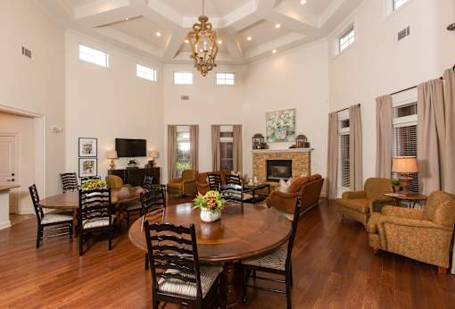 A large dining room with a wooden table surrounded by chairs.