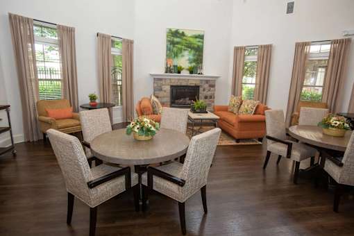 A living room with a fireplace and a dining table.