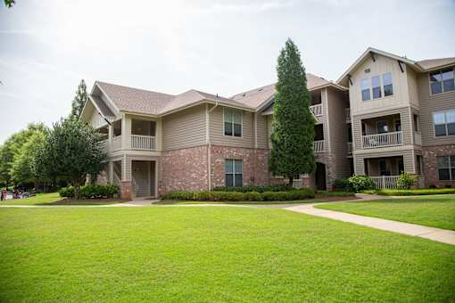Apartment complex with a green lawn in front.