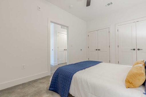 A bedroom with a bed, pillow, and blanket.