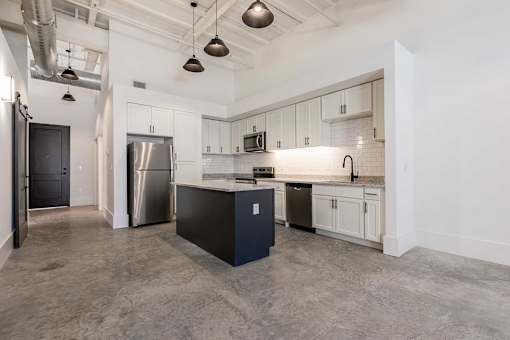A kitchen with a black island in the middle of the room.