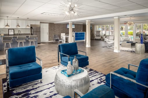 a lobby with blue chairs and a table with vases on top of it at Waterview at Rocky Point, Tampa, 33634