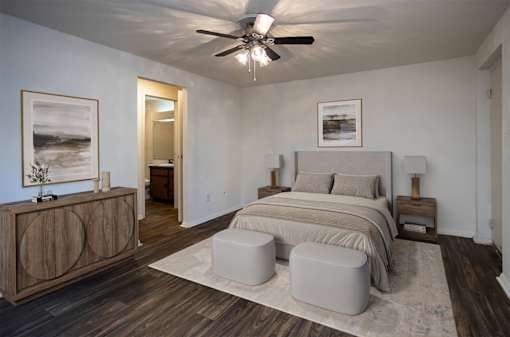 A bedroom with a bed, nightstands, and a ceiling fan.