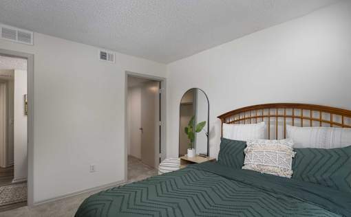 A bedroom with a bed and a mirror on the wall.
