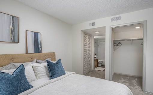 A bedroom with a large bed and a closet.
