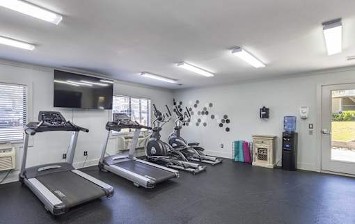 A spacious room with treadmills and elliptical machines.