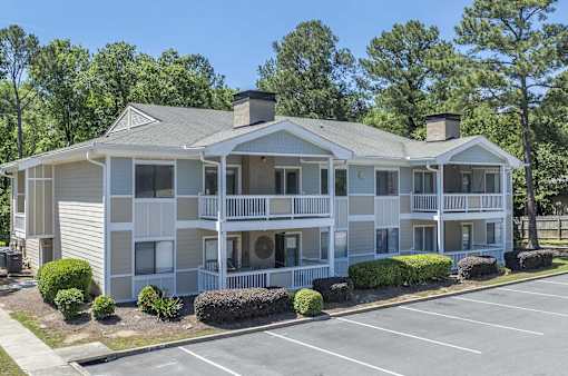 A two-story building with a parking lot in front.