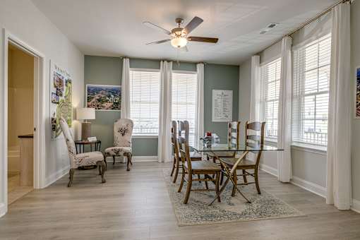 A dining room with a table and chairs.