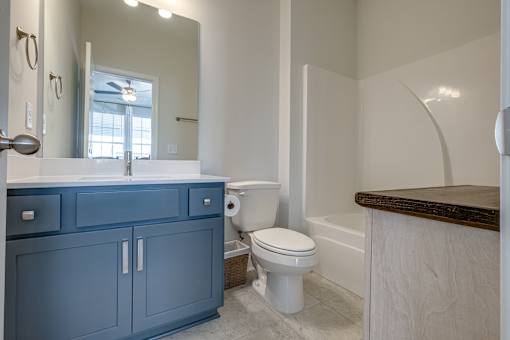 A bathroom with a blue cabinet and white toilet.