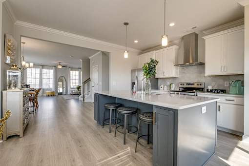 A modern kitchen with a large island and stainless steel appliances.