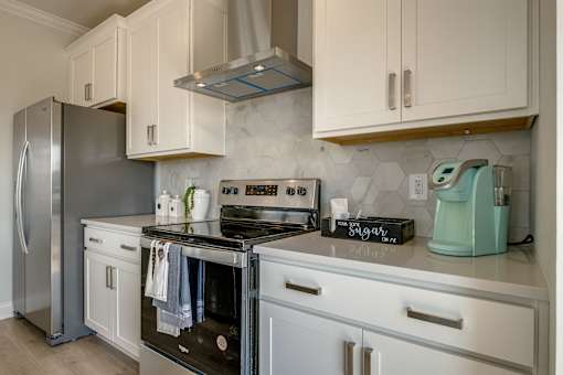 A kitchen with a stove, oven, and refrigerator.