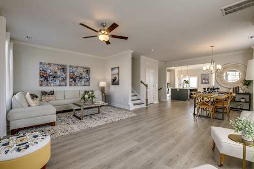 A living room with a couch, coffee table, and a dining table.