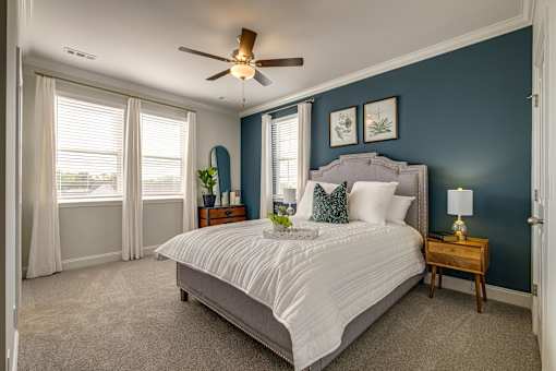 A bedroom with a large bed and a ceiling fan.