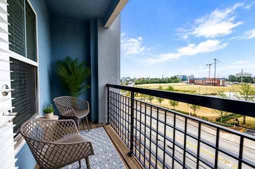 A balcony with two chairs and a table.
