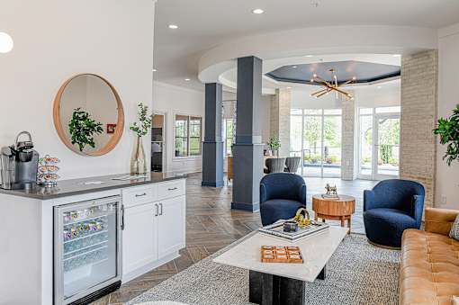 A modern kitchen with a white fridge and a round mirror on the wall.
