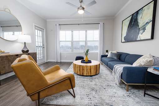 A living room with a yellow chair and a blue couch.