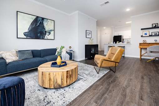 A living room with a blue couch, a wooden coffee table, and a yellow chair.
