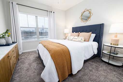 A bedroom with a large bed and a mirror on the wall.