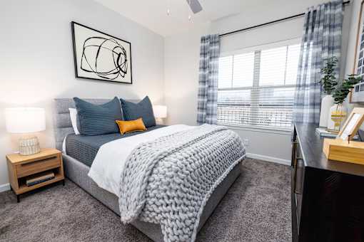 A bedroom with a large bed and a ceiling fan.