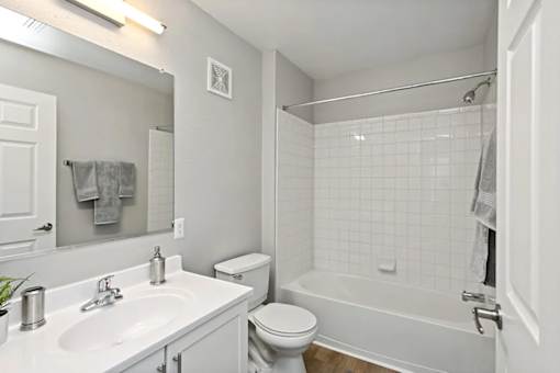 A white bathroom with a toilet, sink, and bathtub.
