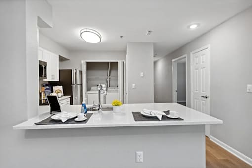 A kitchen with a white countertop and a sink.