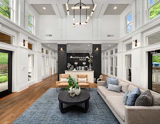 A living room with a sofa, coffee table, and a chandelier.